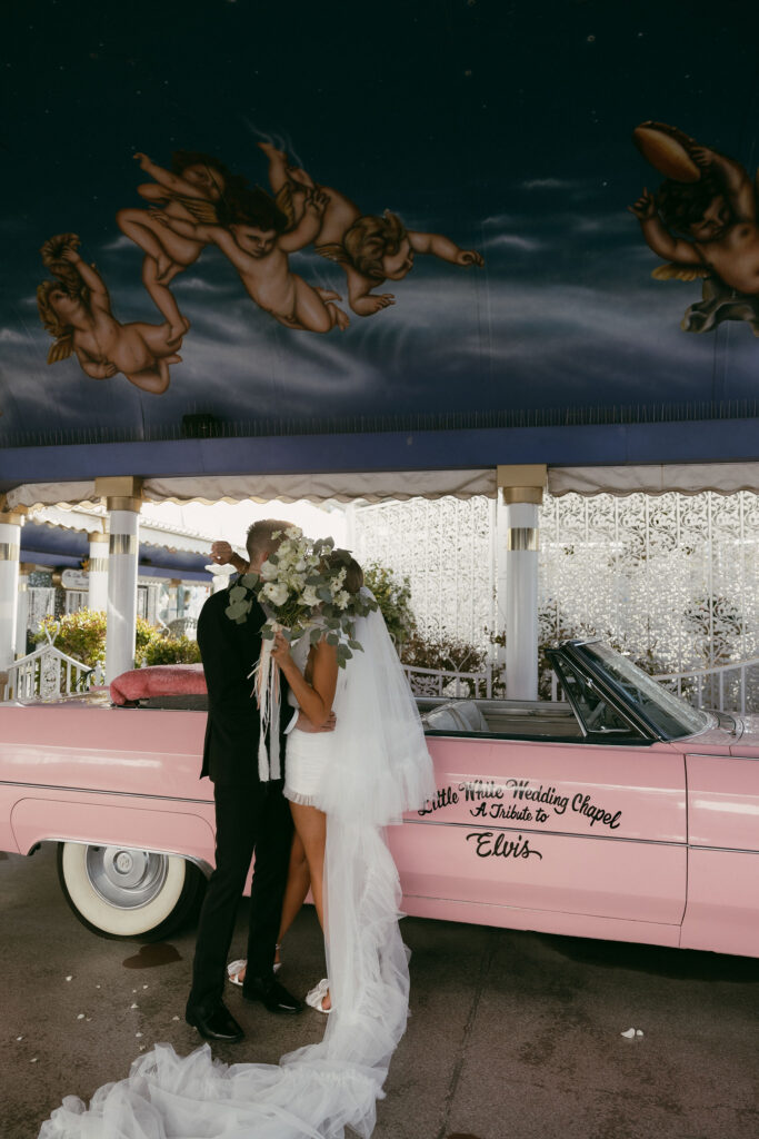 Bride and groom portraits with The Little White Chapels Pink Cadillac for their Las Vegas elopement