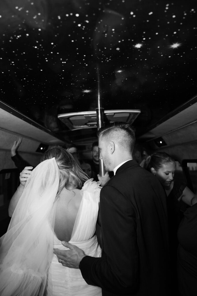 Bride and groom on a party bus with their guests