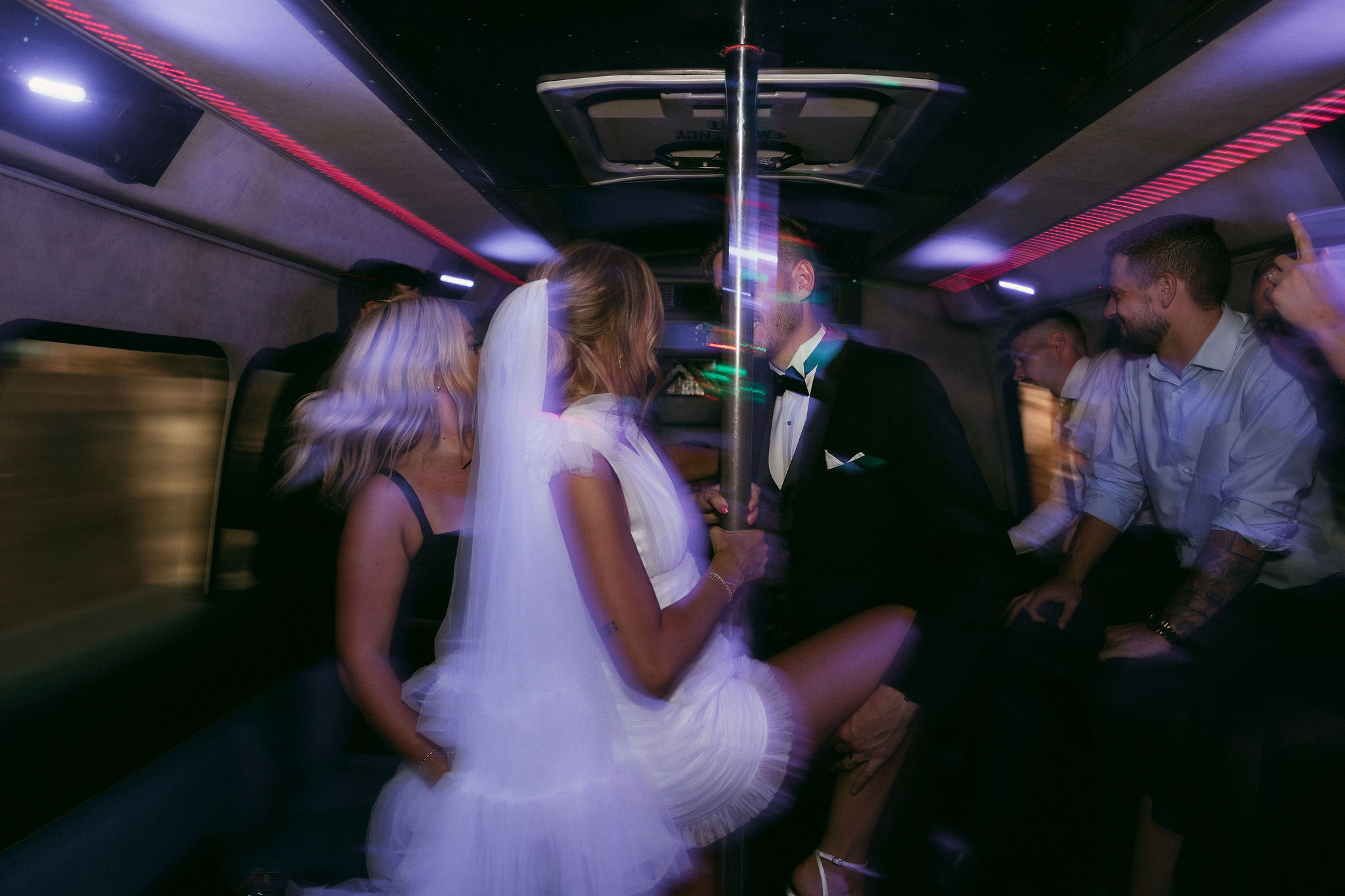 Bride and groom on a party bus with their guests