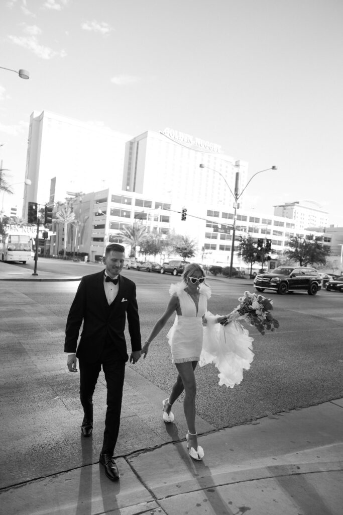 Bride and groom walking down Fremont Street for their Las Vegas elopement portraits