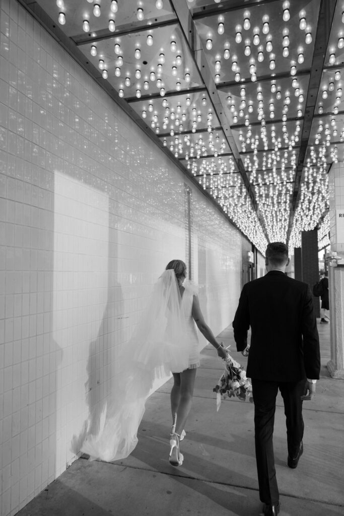 Bride and groom walking down Fremont Street for their Las Vegas elopement portraits