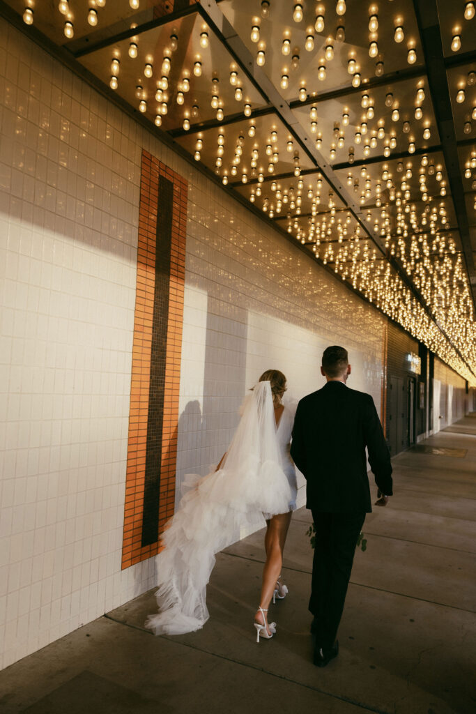 Bride and groom walking down Fremont Street for their Las Vegas elopement portraits