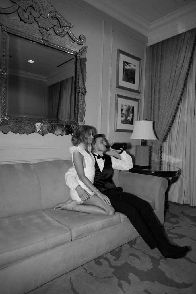 Bride and groom sitting on the couch and drinking champagne