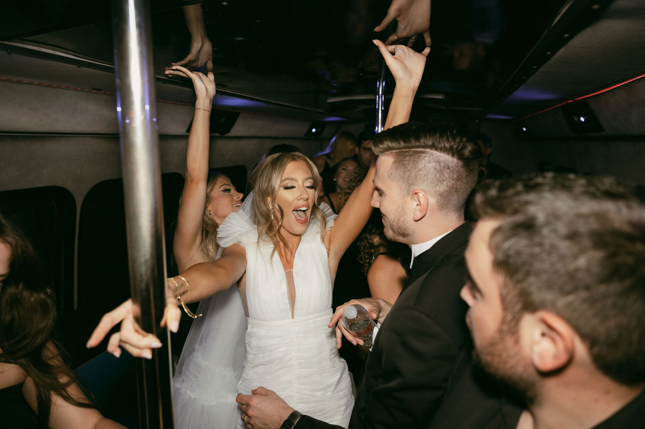 Bride and groom on a party bus with their guests