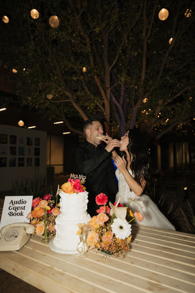 Bride and groom feeding each other wedding cake