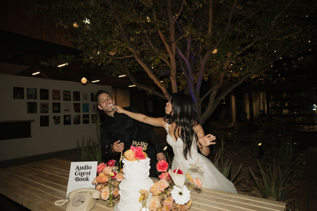 Bride and groom feeding each other wedding cake