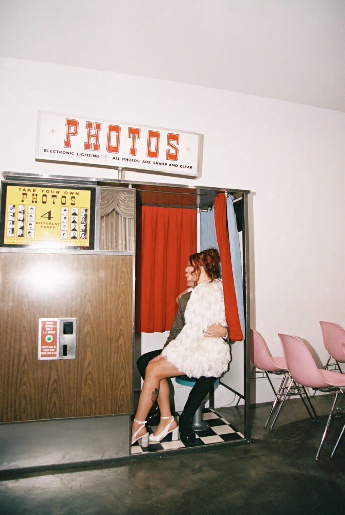 Bride and groom taking photos in Sure Thing Chapels vintage analog photobooth 