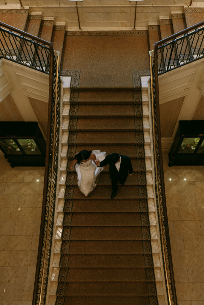 Bride and groom walking down the staircase at Caesars Palace in Las Vegas.