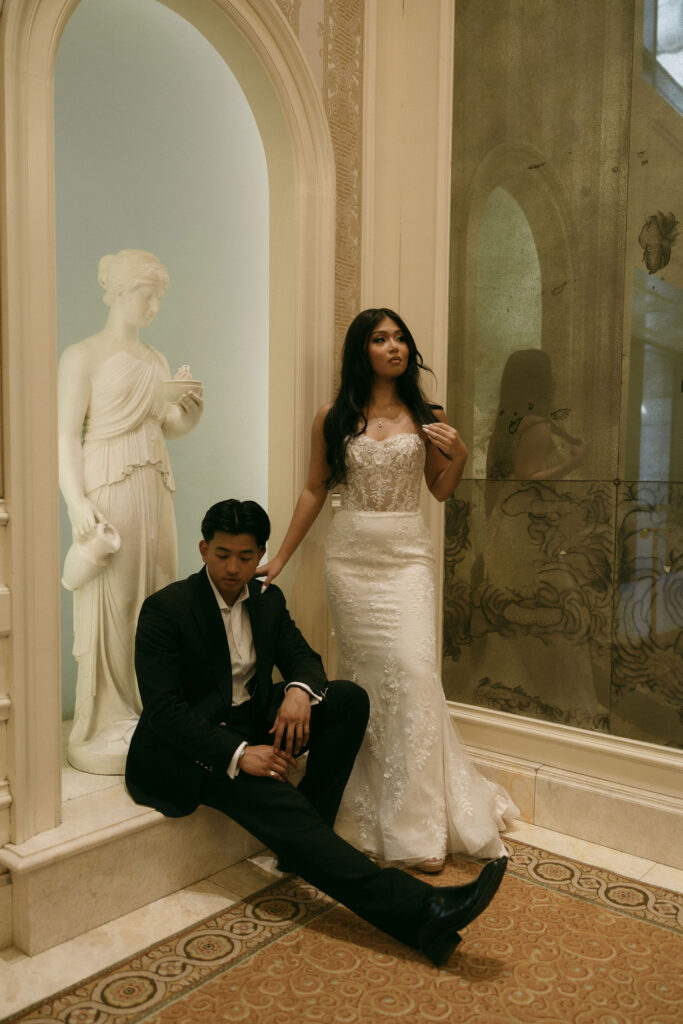 Bride and groom posing for sculptures at Caesars Palace in Las Vegas