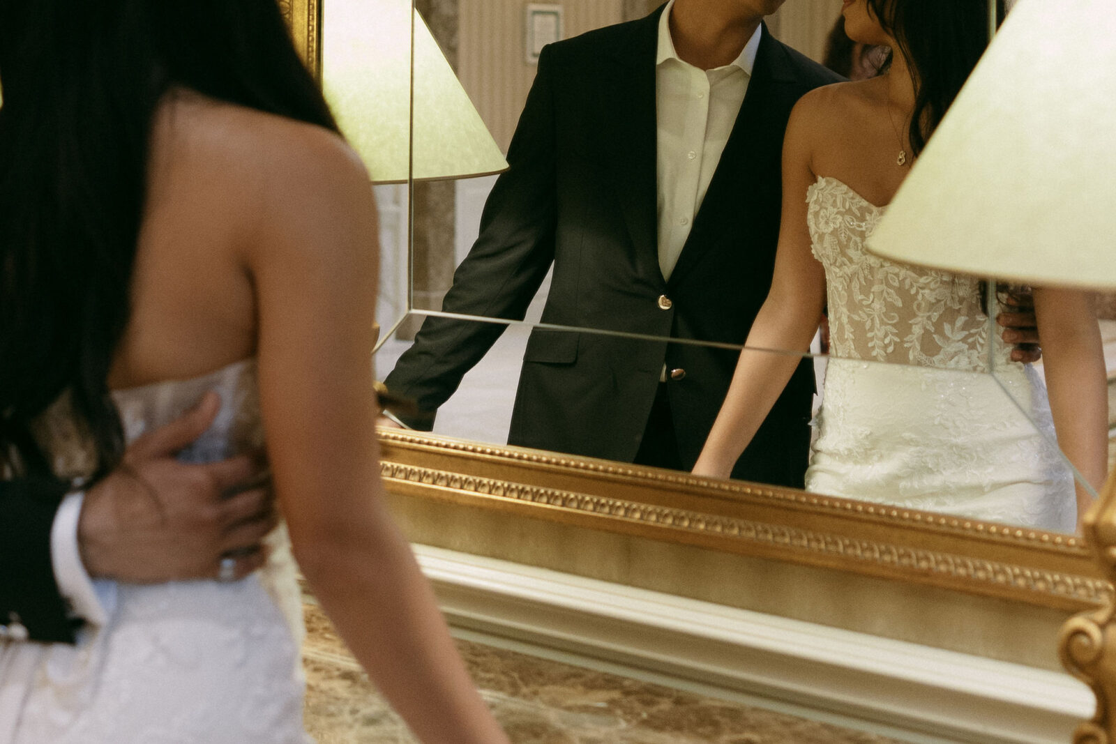 Close up shot of a bride and groom looking at each other in the mirror