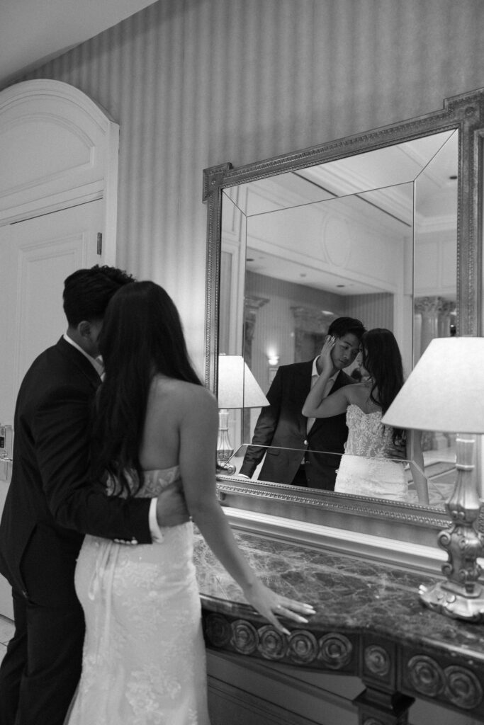 Black and white photo of a bride and groom in a mirror