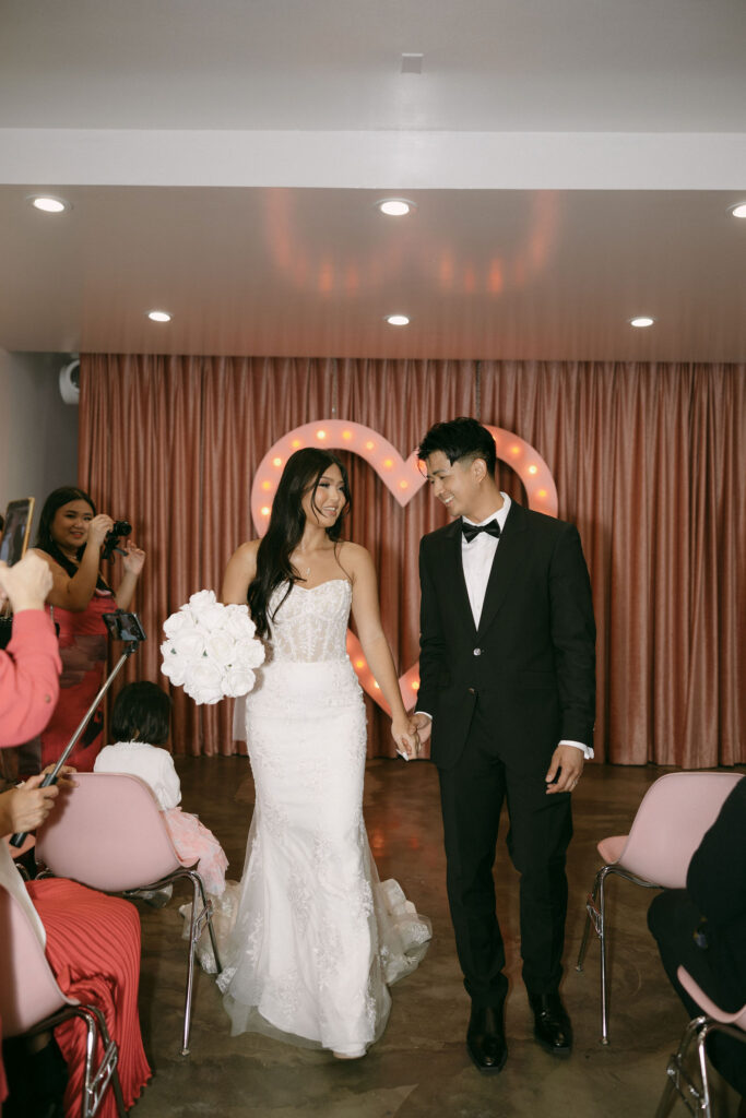 Bride and groom walking back down the aisle together as husband and wife after their Sure Thing Chapel elopement ceremony. 