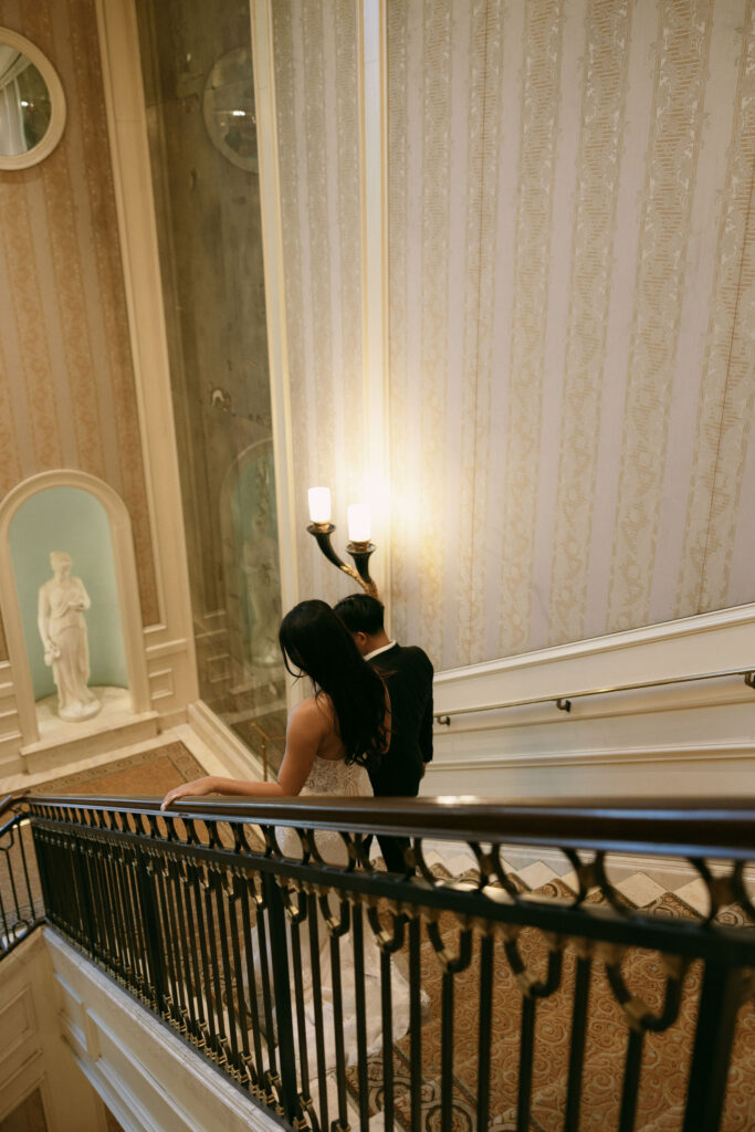 Bride and groom walking down the staircase at Caesars Palace in Las Vegas.