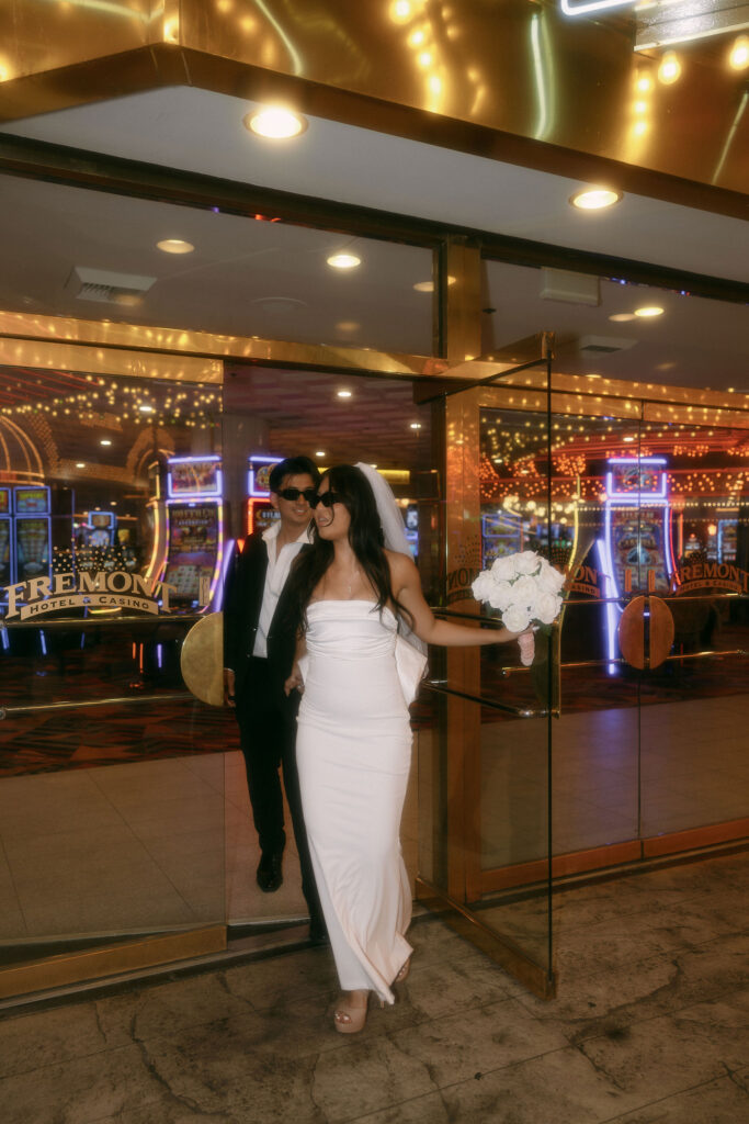 Bride and groom walking along Fremont Street for their elopement in Las Vegas, Nevada