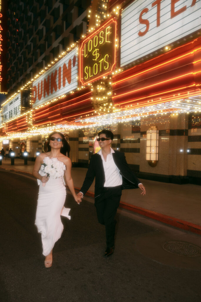 Bride and groom walking along Fremont Street for their elopement in Las Vegas, Nevada