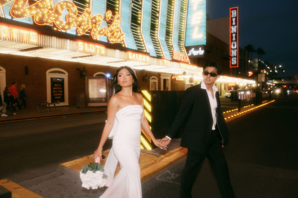 Bride and groom walking along Fremont Street for their elopement in Las Vegas, Nevada