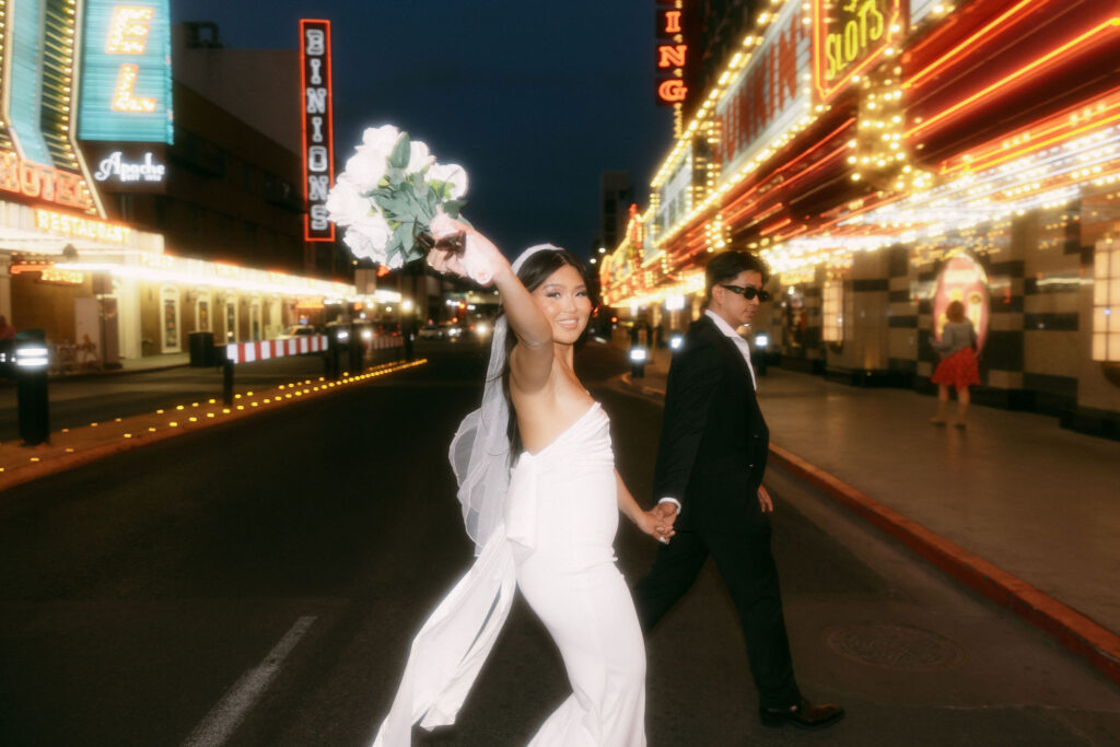 Bride and groom walking along Fremont Street for their elopement in Las Vegas, Nevada