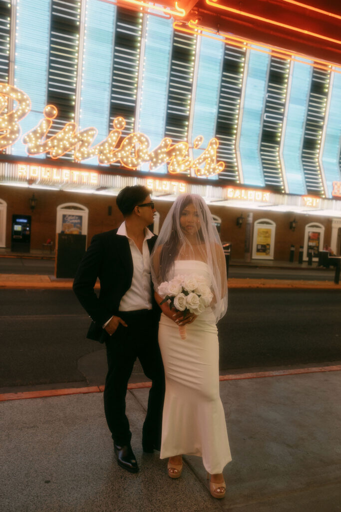 Bride and groom posing for photos on Fremont Street