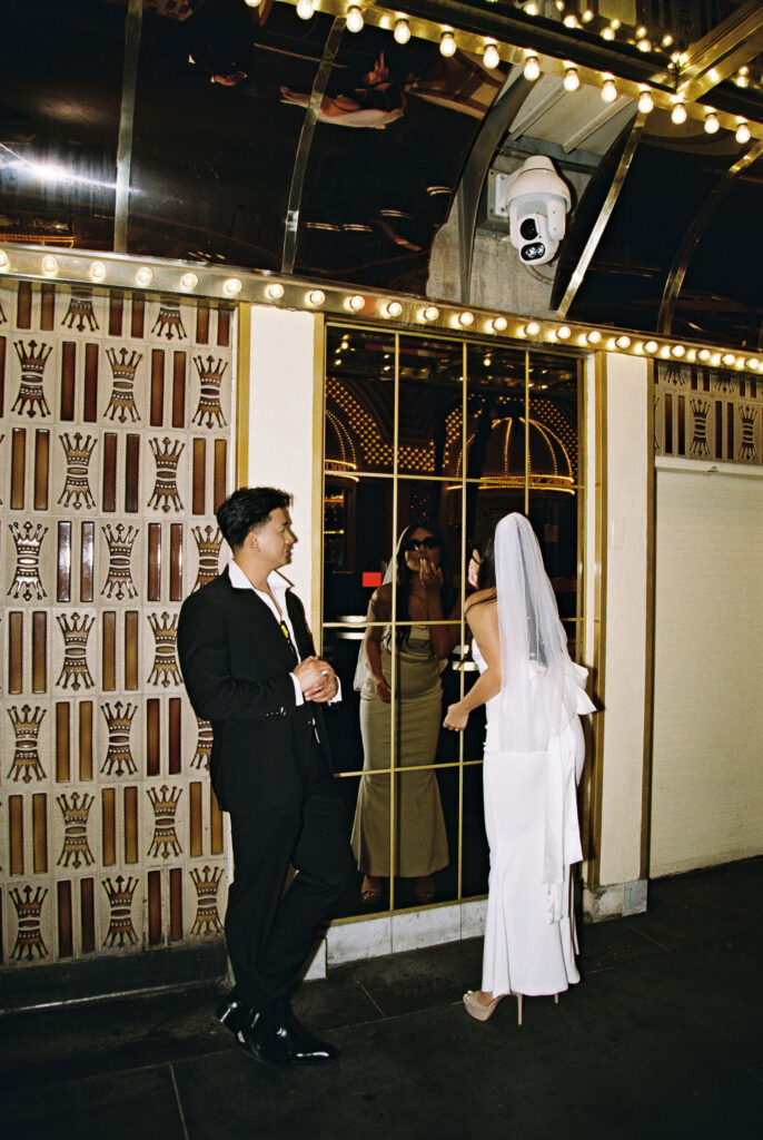 Bride and grooms film photos from their Las Vegas elopement on Fremont Street. 