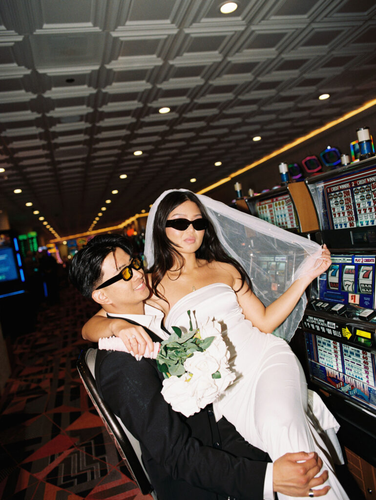 Film photos of a bride and groom playing slots in Las Vegas.