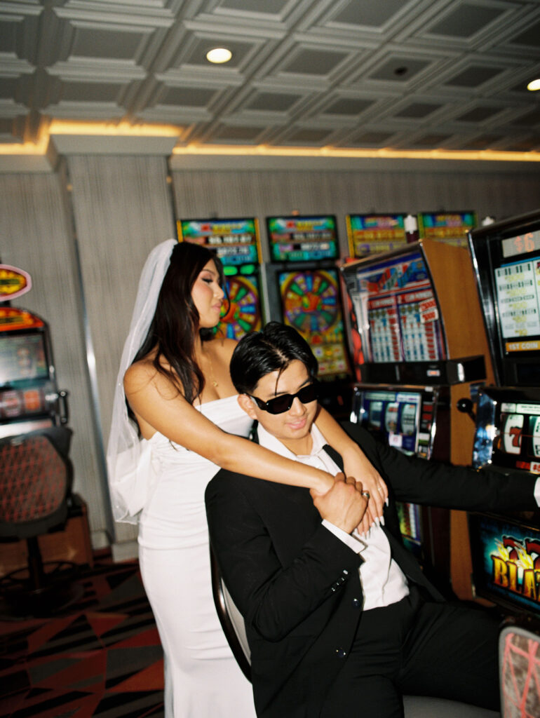 Film photos of a bride and groom playing slots in Las Vegas.