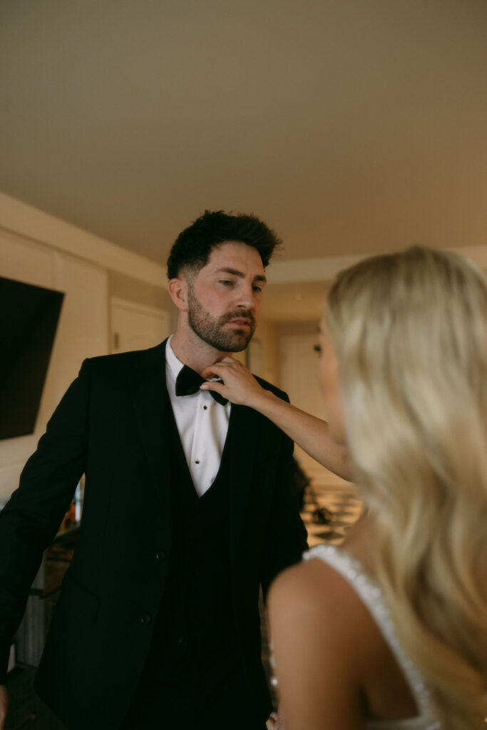 Bride helping groom get ready