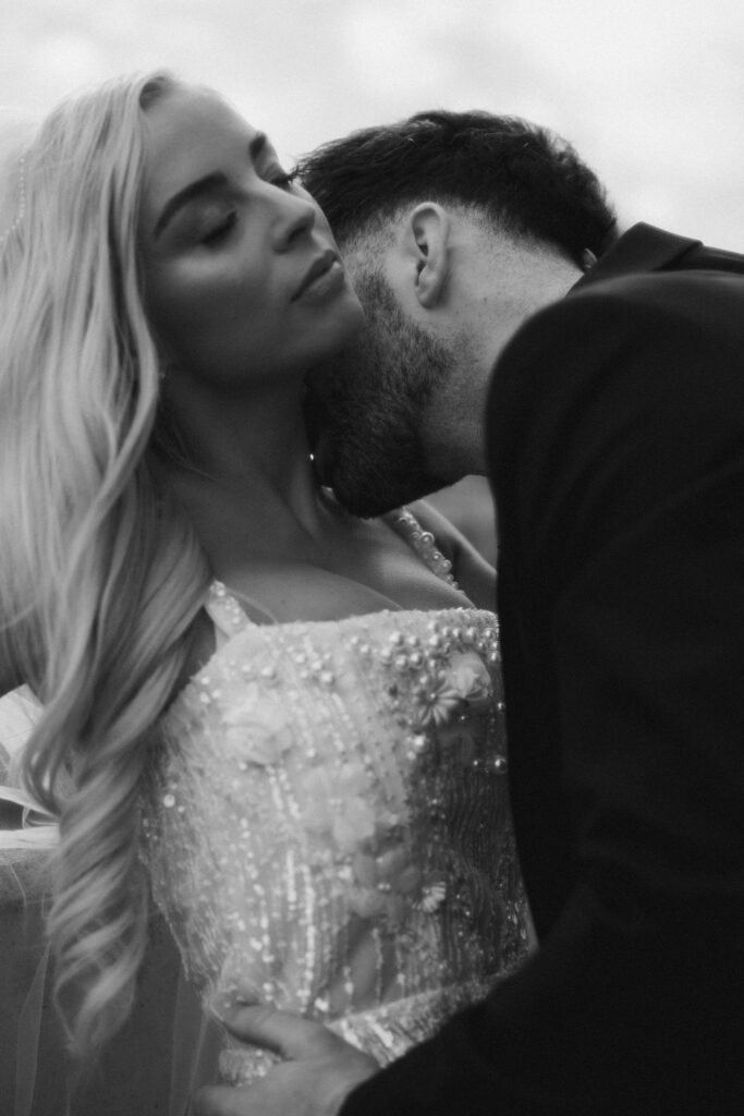 Black and white portrait of a bride and groom on a rooftop