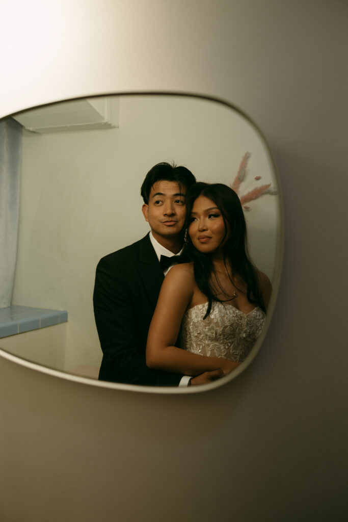 Bride and groom posing in the Sure Thing Chapel bathroom mirror