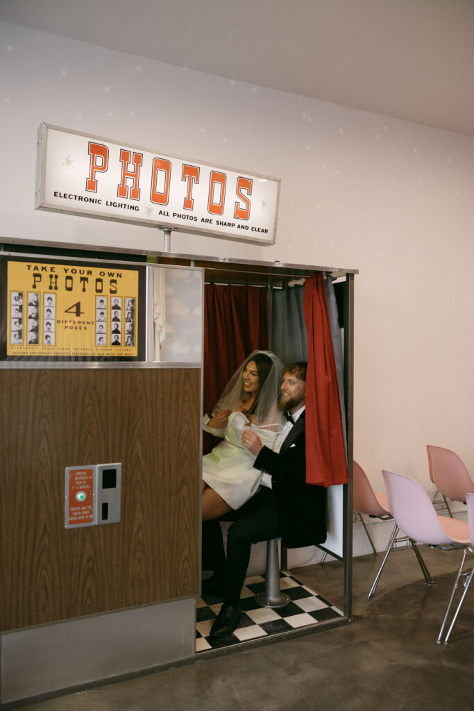 Bride and groom taking photos in the vintage analog photobooth at Sure Thing Chapel Las Vegas