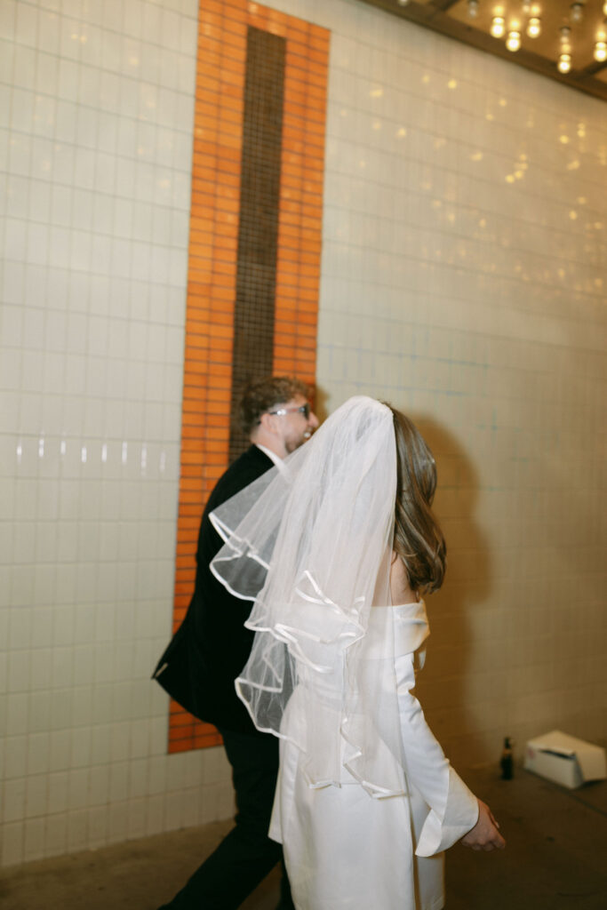 Bride ands groom running down Fremont Street at night