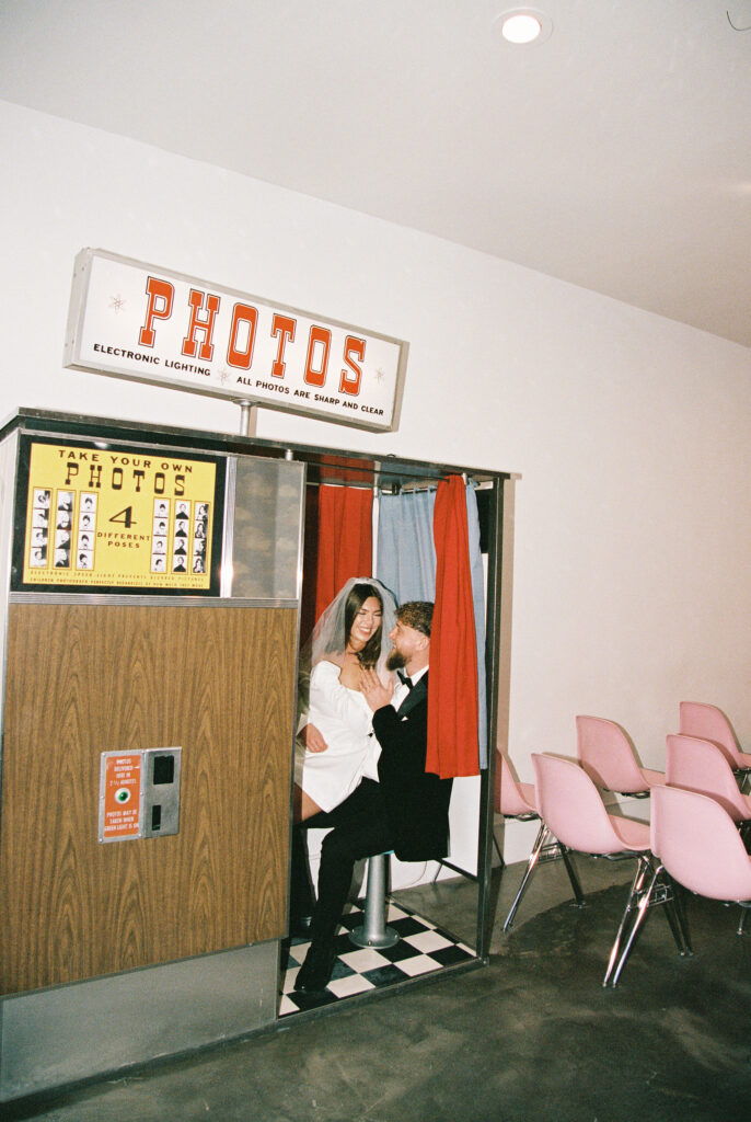 Couple taking photos in Sure Thing Chapels vintage analog photobooth