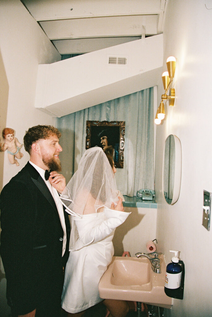 Bride and groom posing for photos in Sure Thing Chapel Las Vegas vintage bathroom