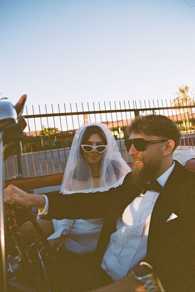 Bride and grooms Las Vegas elopement portraits with a vintage red car captured on film.