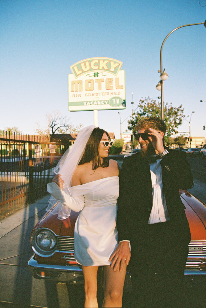 Bride and grooms Las Vegas elopement portraits with a vintage red car captured on film.