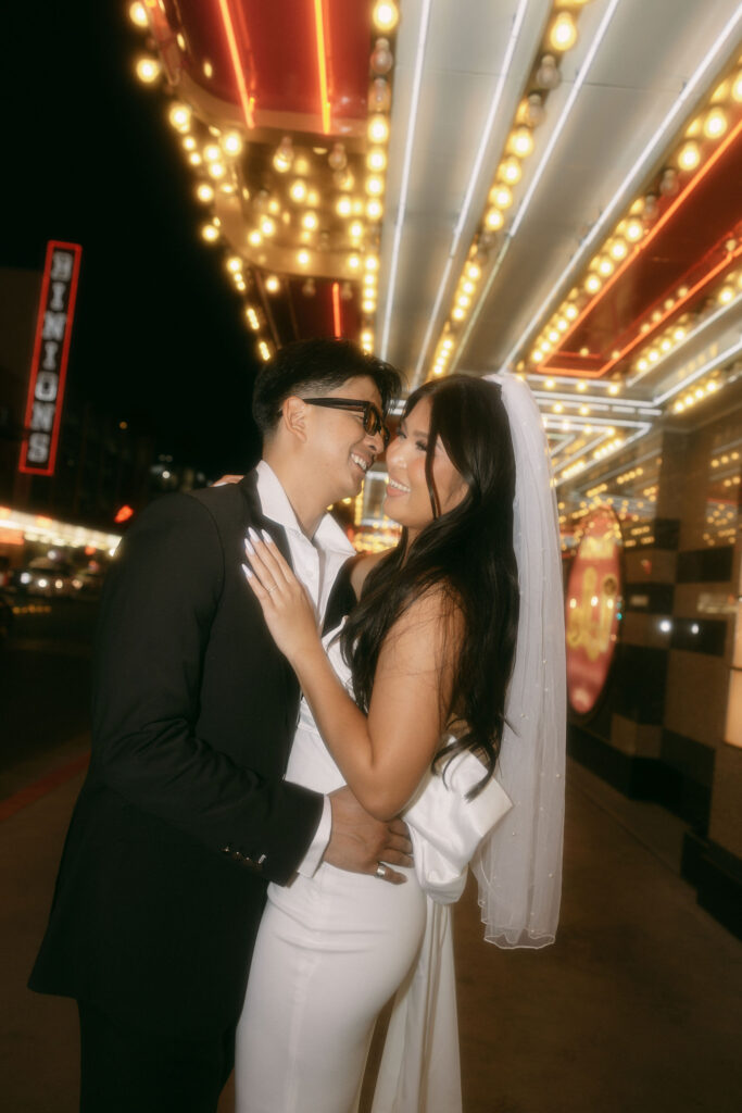 Couple posing for photos on Fremont Street during their Las Vegas elopement photos