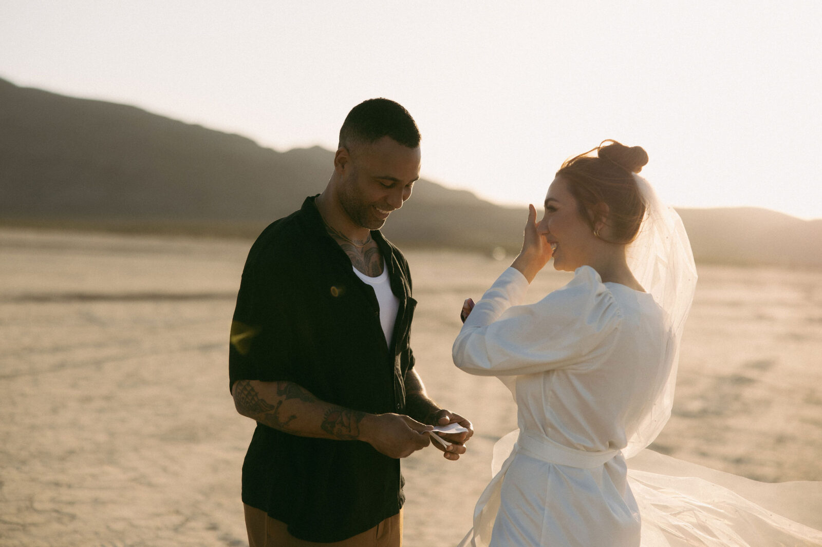 Bride getting emotional as her groom exchanges his vows to her during their Dry Lake Bed Las Vegas wedding ceremony