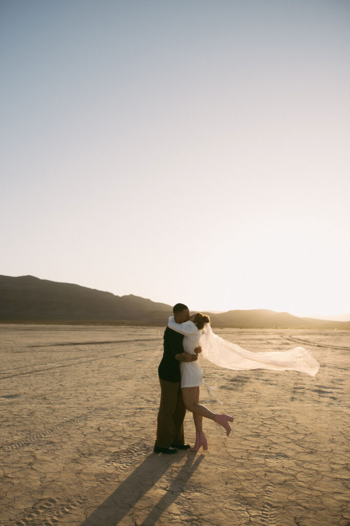 Bride and groom kissing after their Dry Lake Bed Las Vegas wedding ceremony at sunset