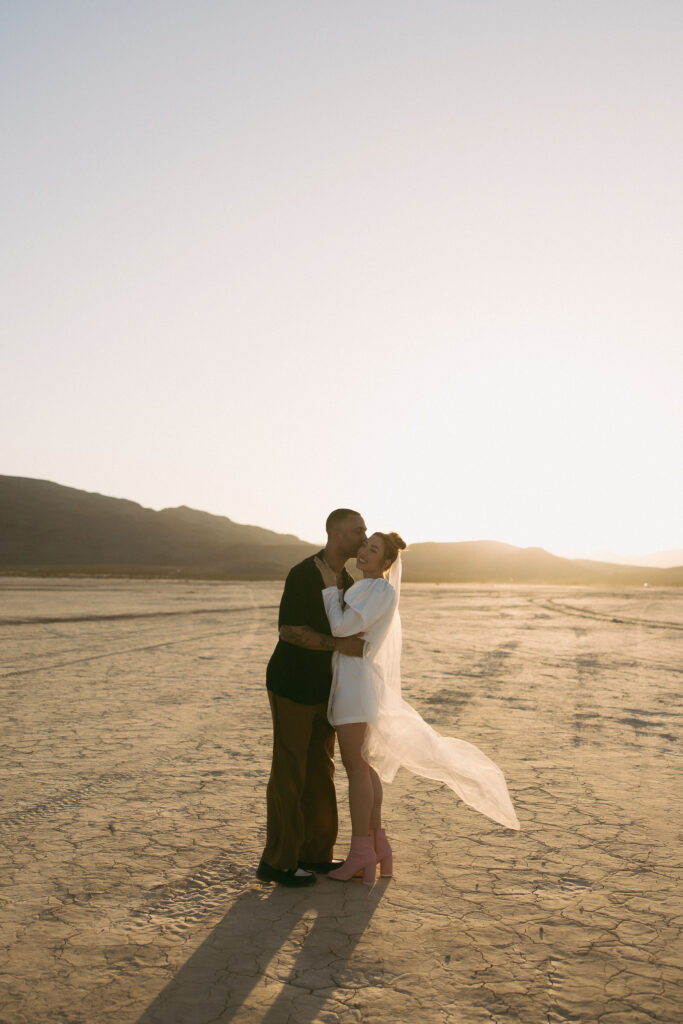 Bride and groom hugging after their Dry Lake Bed Las Vegas wedding ceremony at sunset