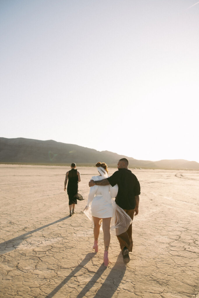 Couple and their officiant walking out for their ceremony at Jean Dry Lake Bed in Las Vegas