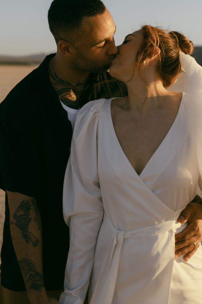 Bride and grooms kissing during their portraits from a dreamy and intimate Dry Lake Bed Las Vegas wedding