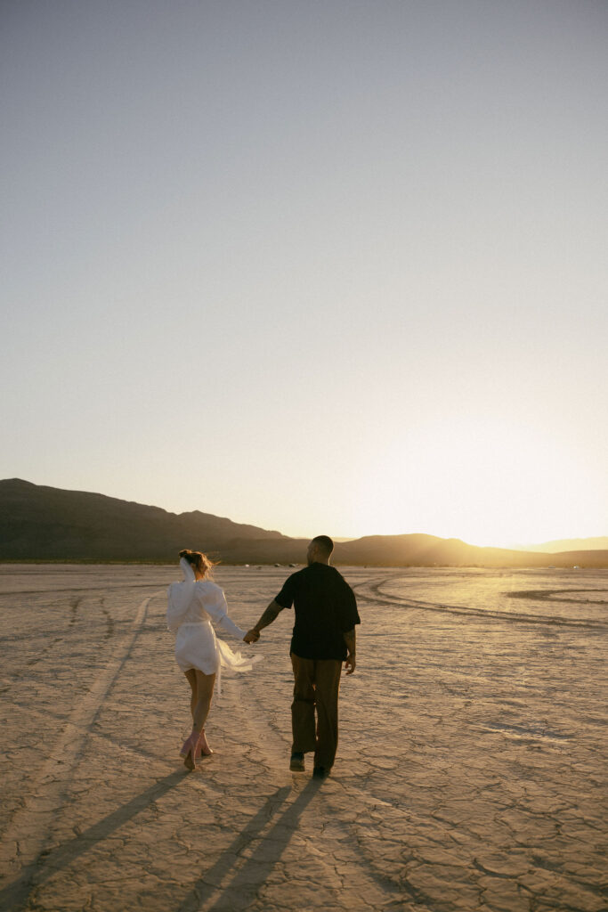 Bride and groom walking in the desert during their dreamy and intimate Dry Lake Bed Las Vegas wedding