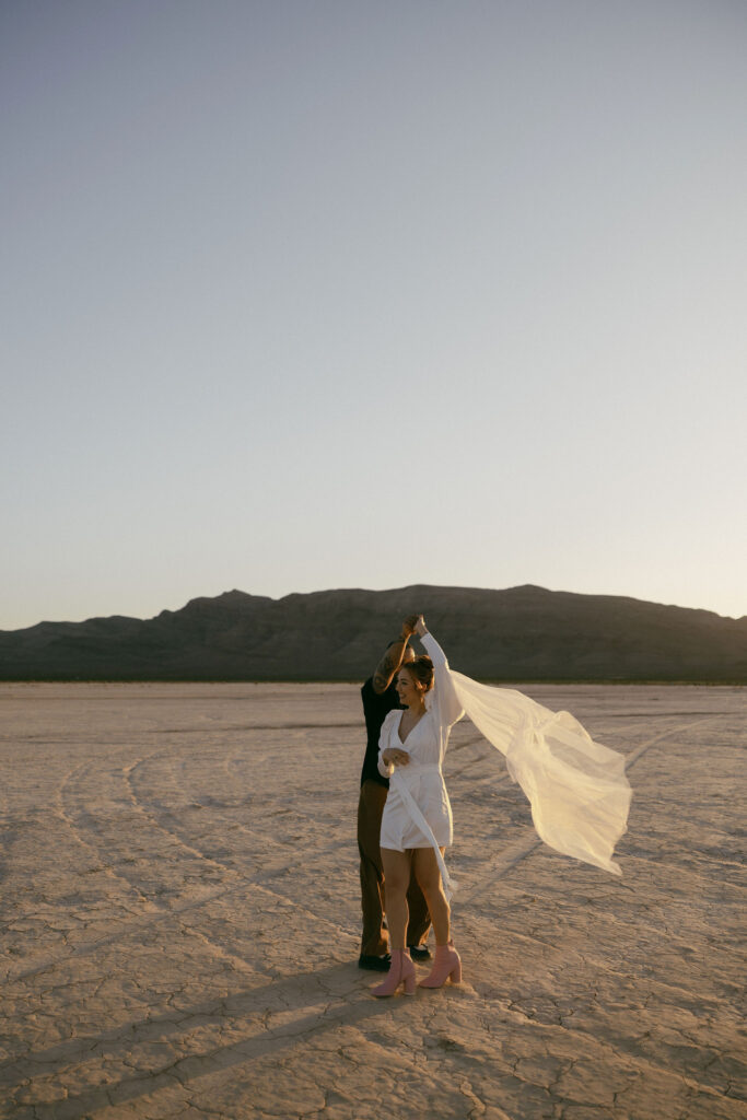 Bride and groom dancing in the desert during their Dry Lake Bed Las Vegas wedding portraits at sunset