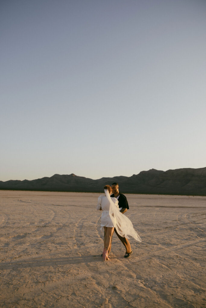 Bride and groom dancing in the desert during their Dry Lake Bed Las Vegas wedding portraits at sunset