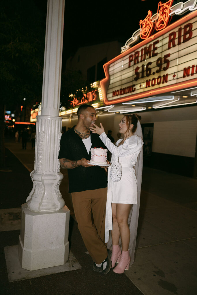 Bride feeding her groom frosting from their pink elopement cake