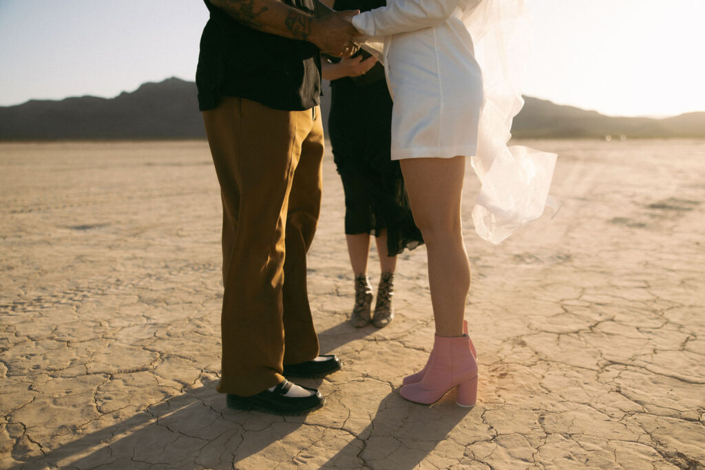 Bride and groom holding each others vows during their intimate Dry Lake Bed Las Vegas wedding ceremony