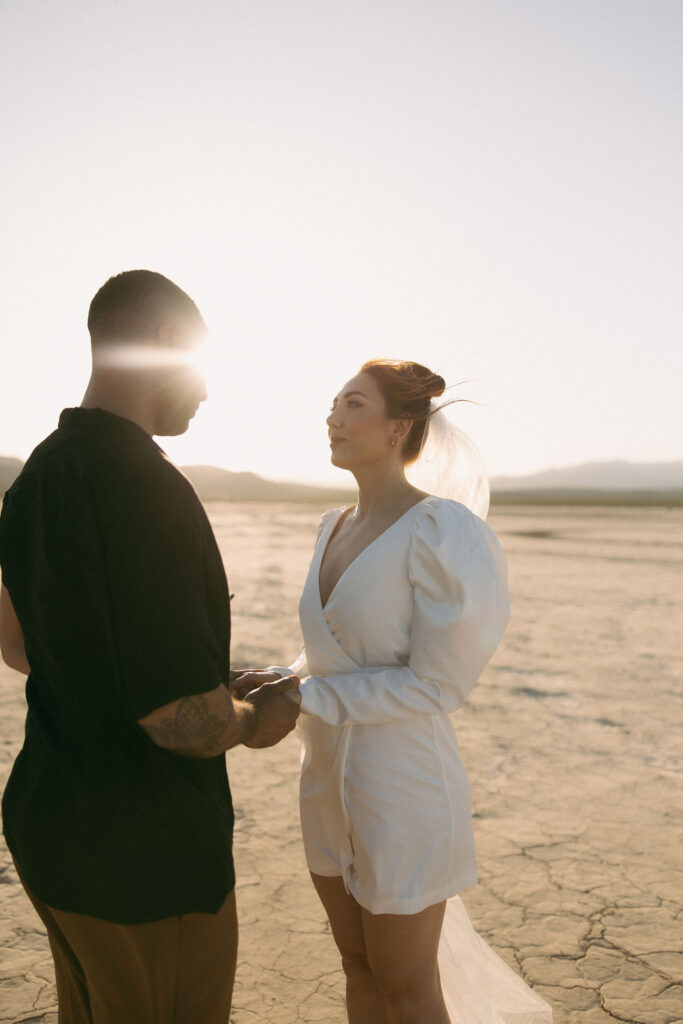 Bride and groom holding each others vows during their intimate Dry Lake Bed Las Vegas wedding ceremony