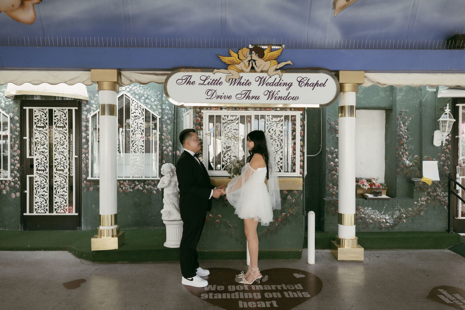 Bride and groom getting married at The Little White Wedding Chapels Drive Thru Window in Las Vegas