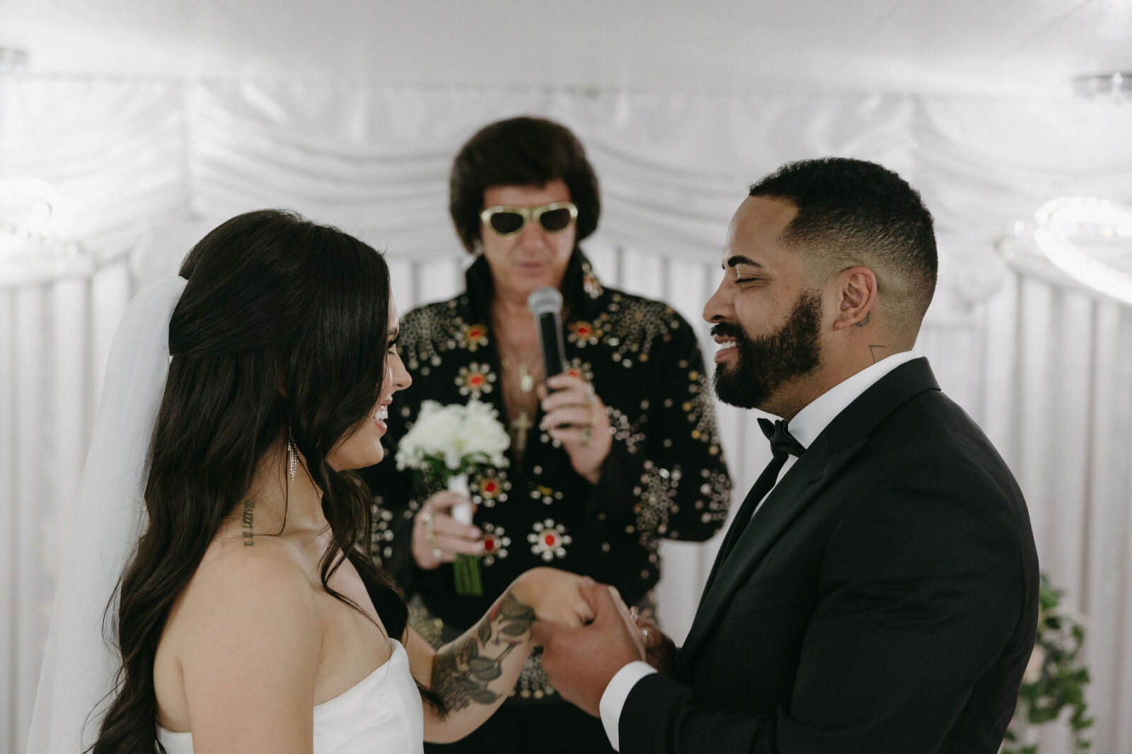 Bride and groom getting serenaded to by an Elvis impersonator at The Little White Wedding Chapel