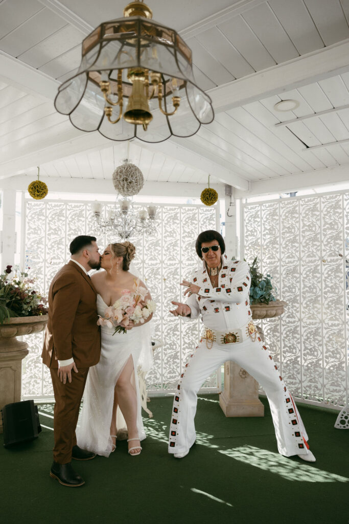 Bride and groom getting married by an Elvis impersonator in the Gazebo at The Little White Wedding Chapel