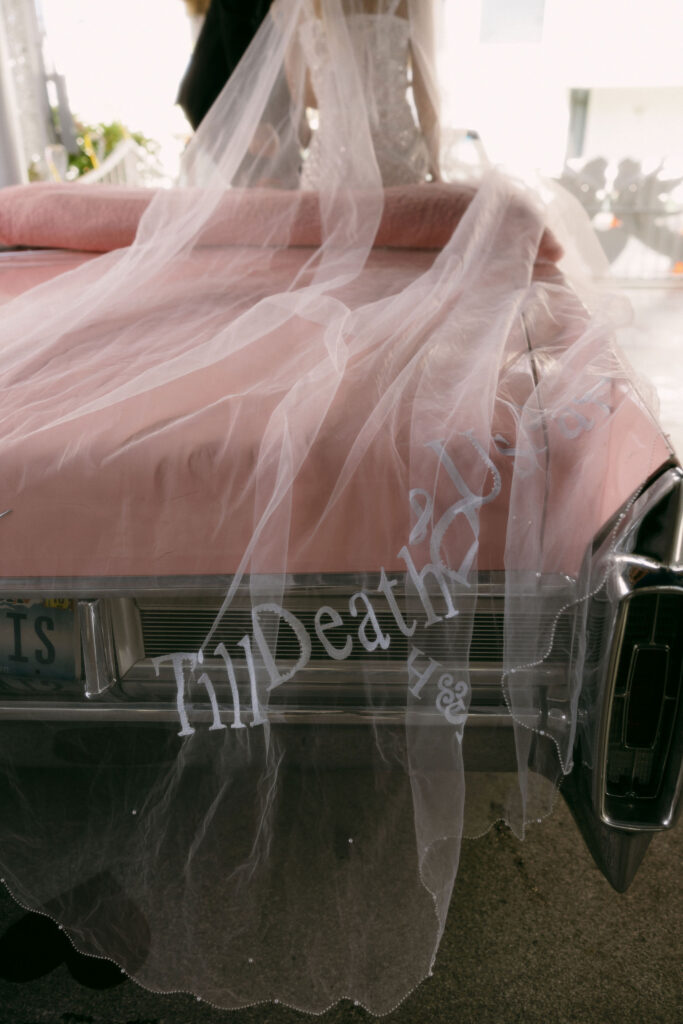 Wedding veil hanging off the end of The Pink Cadillac that says "Till Death"